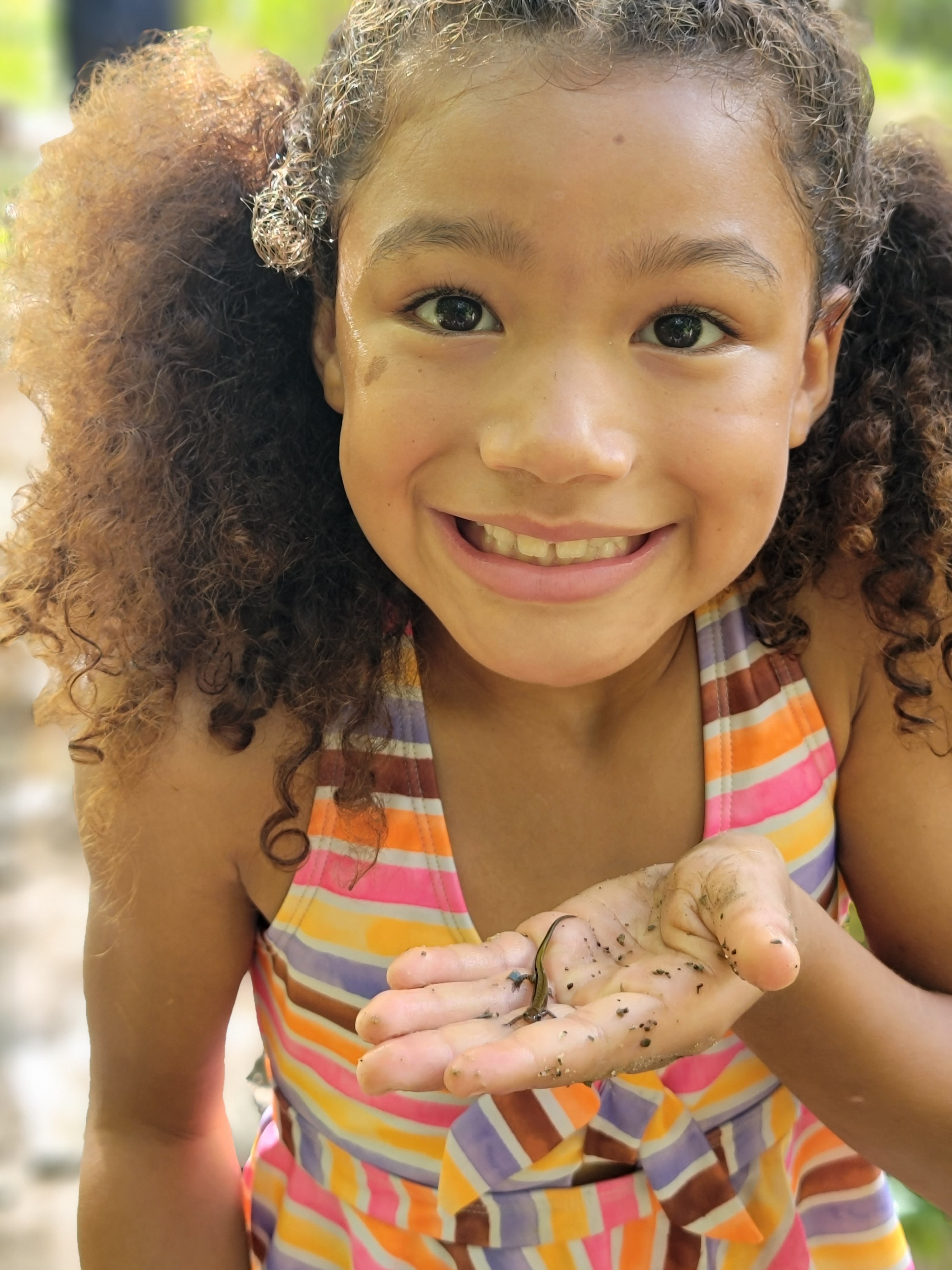Young girl named Addy holds a small lizard.